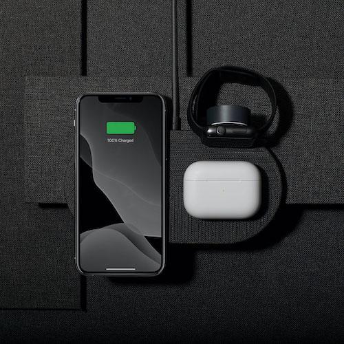 Black iPhone, AirPods and Apple Watch on a black wireless charger
