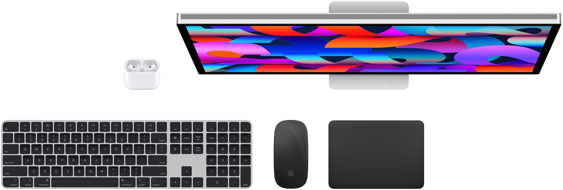 Mac-tilbehør vist ovenfra: Studio Display, AirPods, Magic Keyboard, Magic Mouse og Magic Trackpad