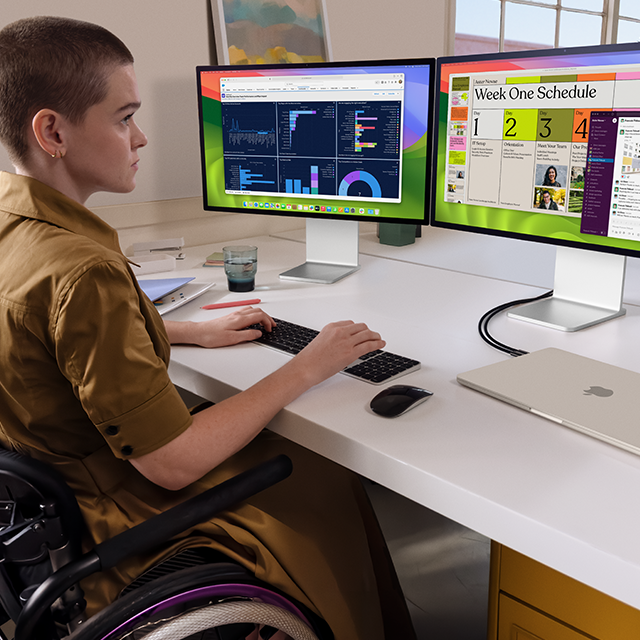 En person som jobber på to eksterne skjermer som er koblet til en lukket 15-tommers MacBook Air i stjerneskinn