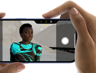 En person holder en iPhone 16 og tar et bilde