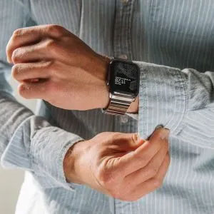 man buttoning shirt cuffs with Apple Watch on wrist
